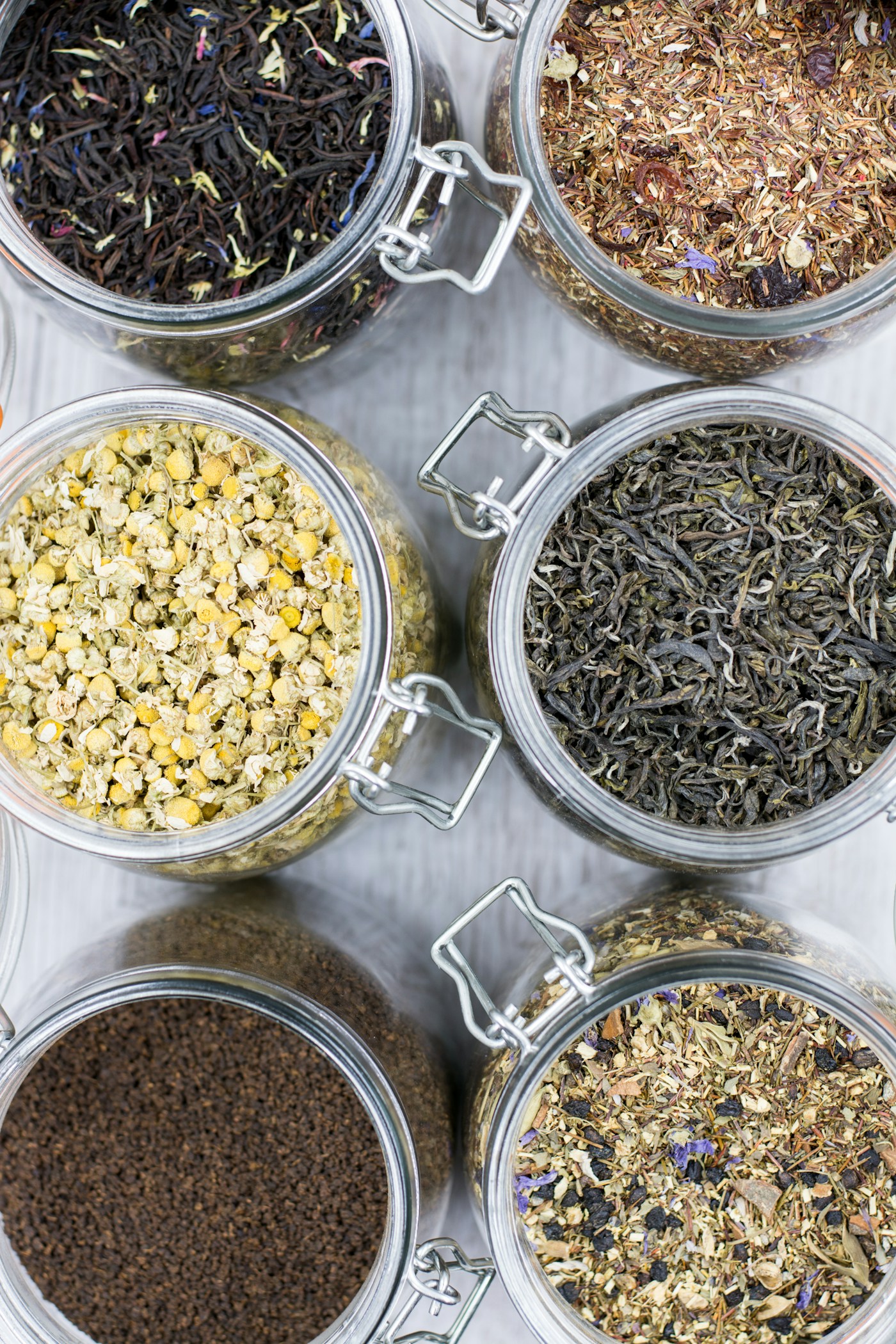 Loose-leaf teas and dried botanicals in glass jars